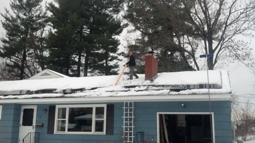 Nik and the only thing that will budge the ice: a 2X4. The lower panels had been cleared a few days before, using a windshield scraper.